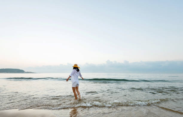 istock Woman walking on the beach 2080338857