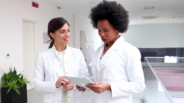 Two female doctors consulting about some patients