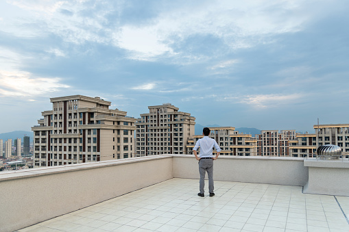 Businessman looking at cityscape on the rooftop.