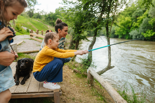 Photo of a family fishing along the riverbank.