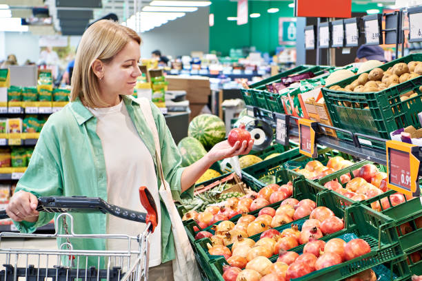 istock Woman buying pomegranate fruit in store 2080350446