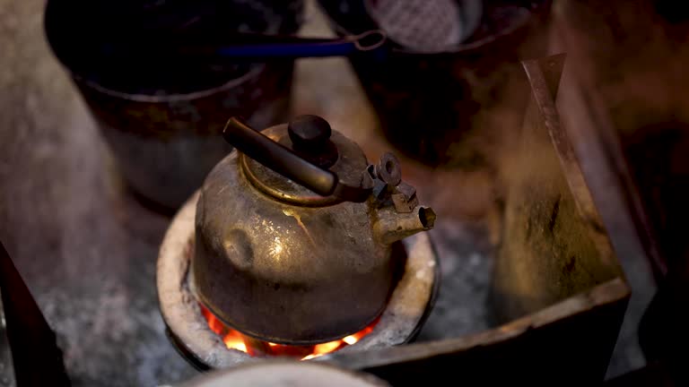 Traditional Kettle Boiling Over Charcoal Fire