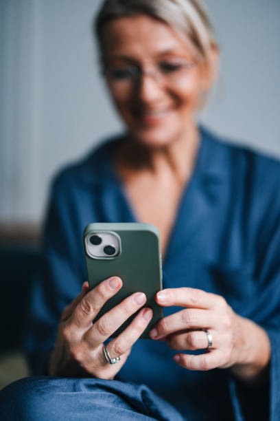 istock Anonymous Older Woman Holding and Using Mobile Phone in Bed 2080404780