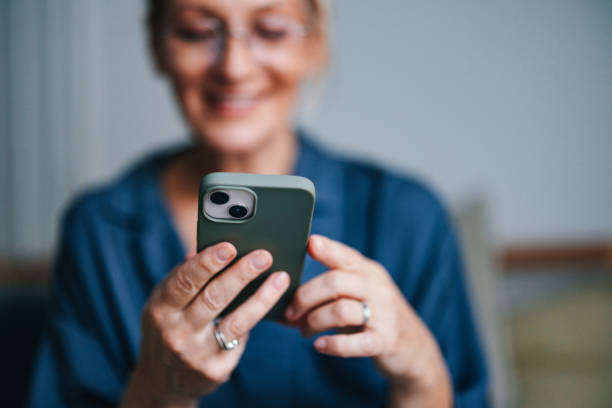 istock Anonymous Older Woman Holding and Using Mobile Phone in Bed 2080405295