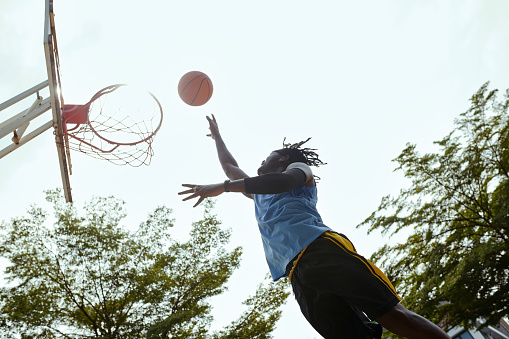 Player throwing ball in basket when playing outdoors