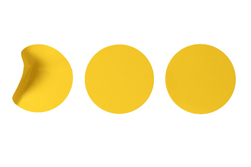 Round yellow stickers, blank tags labels isolated on a white background. Top view.