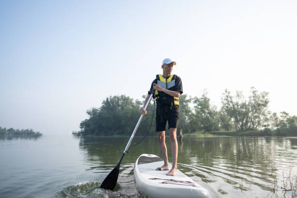 istock Standing up paddling at lake 2080452264