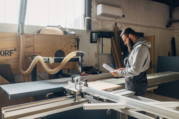 istock Focused craftsman prepares for cutting chipboard in the workshop using an industrial circular saw 2080460743