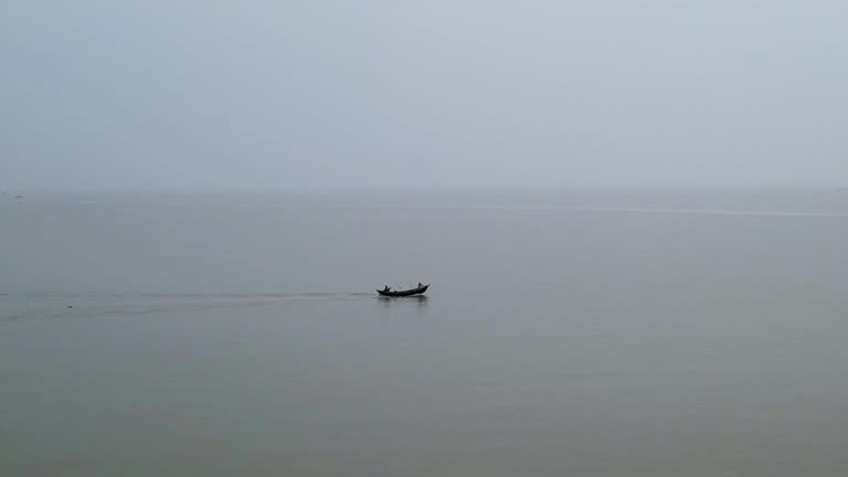 Kuakata Beach and Small Engine Boat Heading Out to Fish at Sea on Calm Waters