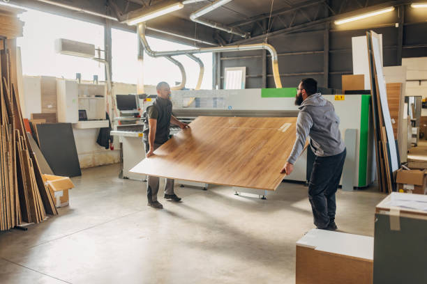 istock Two experienced workers work together in a furniture workshop, taking chipboard and preparing it for processing 2080466668