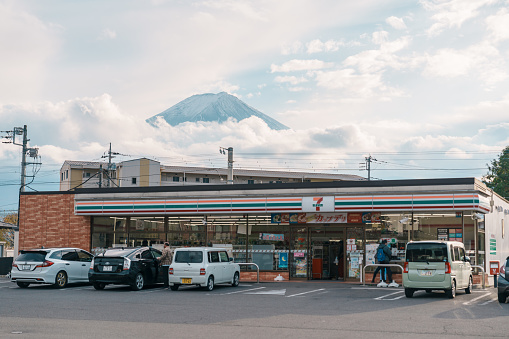 Seven Eleven shop with mount Fuji behind at Kawaguchiko station. Landmark and popular for tourists attractions in Japan. Yamanashi, Japan, 15 November 2023