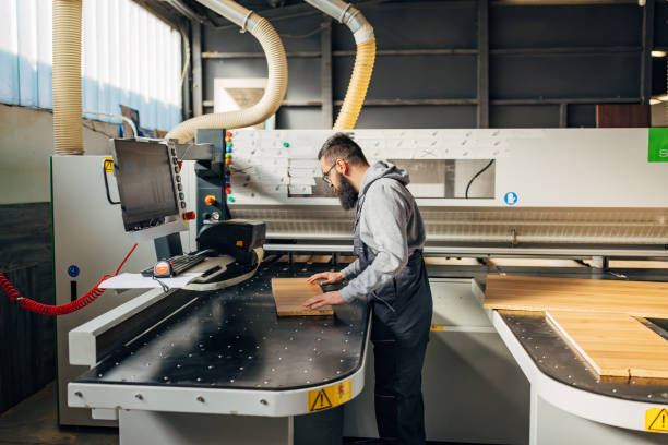 istock Male worker uses industrial cutting machine for automatic wood cutting 2080480377