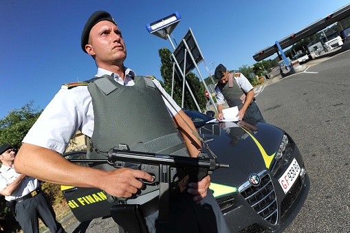 Italian Guardia di Finanza Forces with cars and patrols check with an armed checkpoint and with bulletproof vests driver's licenses, goods on cars and trucks, drugs and all commerce for the safety of the country. They write penalty tickets and fines for drivers who are not in compliance.