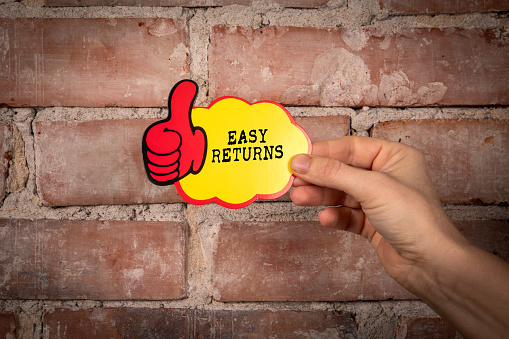 Easy Returns. Sticky note with text on a red brick background.