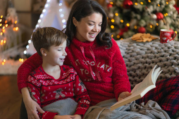 istock Mother and son reading a book during Christmas time at home 2080524732