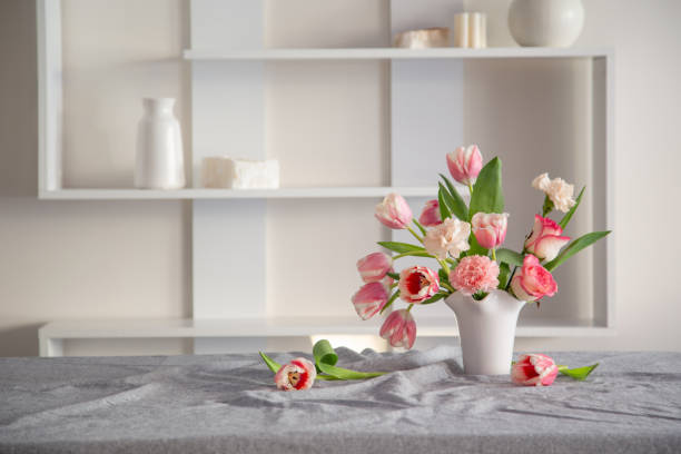 istock pink spring flowers in white ceramic vase in modern home interior 2080536716