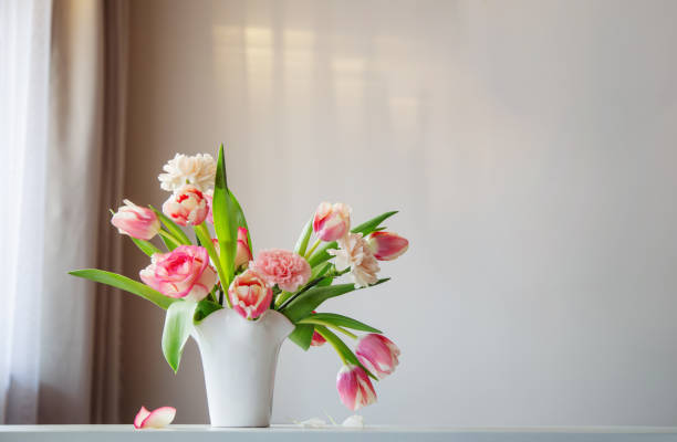 istock pink spring flowers in white ceramic vase in modern home interior 2080536718