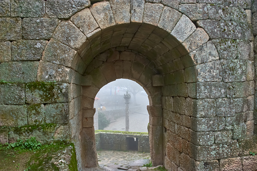 Gate of Betrayal at Sortelha Castle in Portugal where the Manueline pelourinho is seen in the fog