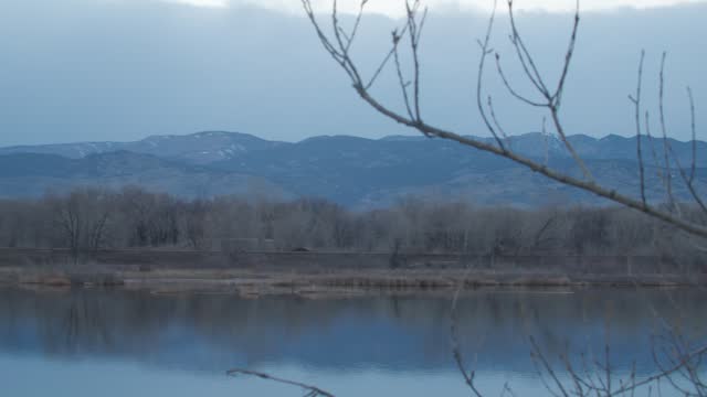 Pond Overlooking Beautiful Mountain Range During Evening Gloomy Light