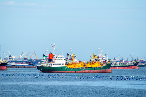 Fleet of oil tanker anchors near the port waiting for loading cargo.