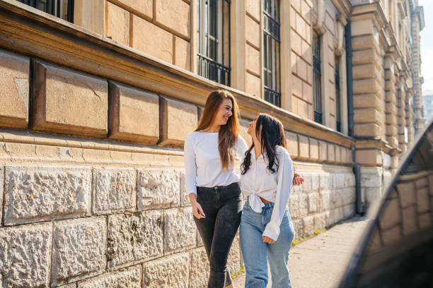 istock Two Female Friends Embracing While Walking In The City 2080588114