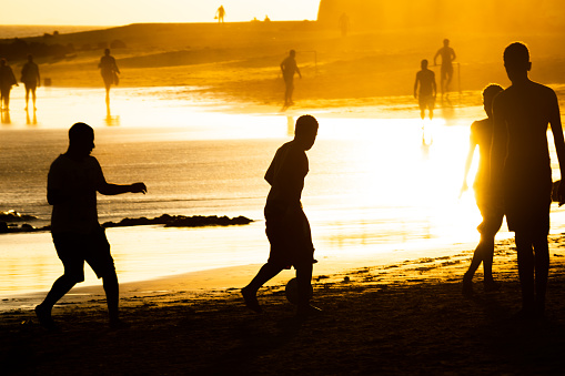 Salvador, Bahia, Brazil - February 14, 2019: People are seen playing beach soccer on Ondina beach during sunset in Salvador, Bahia.
