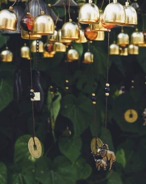 istock Golden Wind Chimes with Elephant Charm Amidst Green Foliage 2080592332