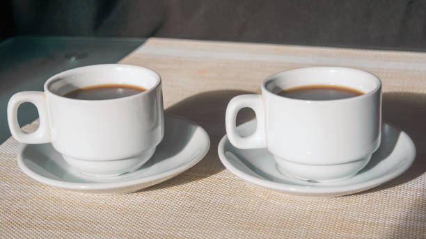 istock Two white cups with black coffee on the table close-up. 2080594439