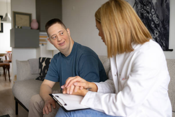 istock Happy man with special needs talking to his doctor at home. 2080597591