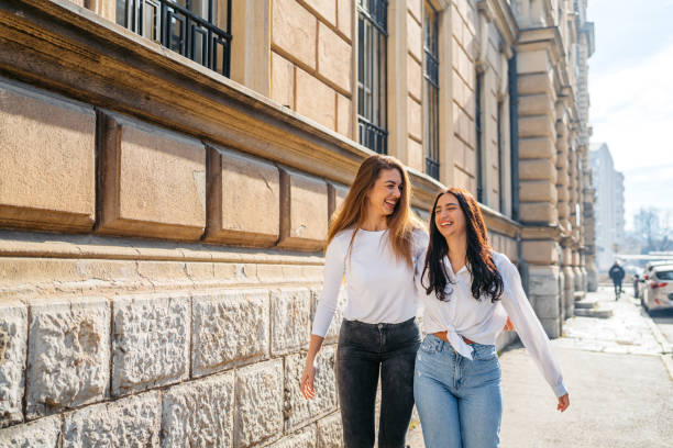 istock Two Female Friends Embracing While Walking In The City 2080600708