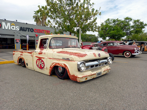 Buenos Aires, Argentina - Feb 25, 2024; Old cream aged paint 1957 Ford F 100 lowrider pickup truck at a classic car show in a parking lot. Sunny day. Copy space