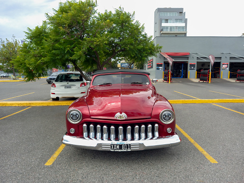 Bernal, Argentina – September 19, 2022: Bernal, Argentina - Sept 18, 2022: Old red burgundy 1957 Chevrolet Chevy Bel Air sport sedan two door parked in the street. Iconic classic car.