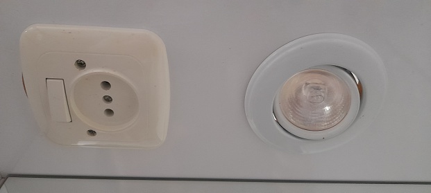 Part of a white socket on the wall