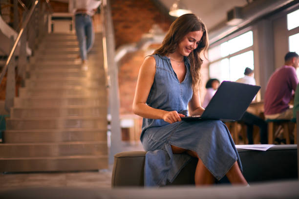 istock Young Smiling Businesswoman Working In Open Plan Office With Colleagues In Background 2080639452