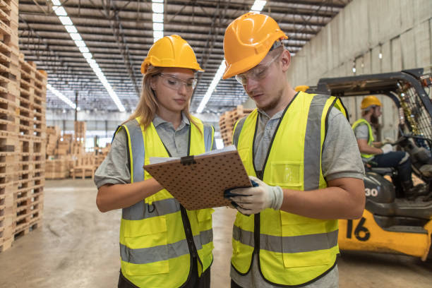 istock Team engineer carpenter wearing safety uniform and hard hat working holding clipboard checking quality of wooden products at workshop manufacturing. man and woman worker wood warehouse industry. 2080677702