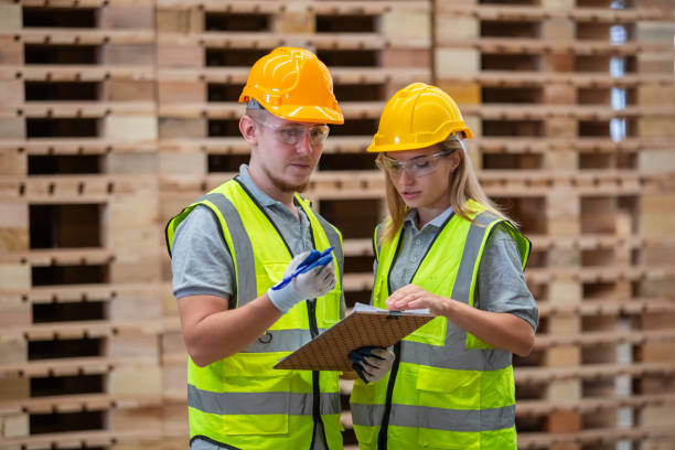 istock Team engineer carpenter wearing safety uniform and hard hat working holding clipboard checking quality of wooden products at workshop manufacturing. man and woman worker wood warehouse industry. 2080678747