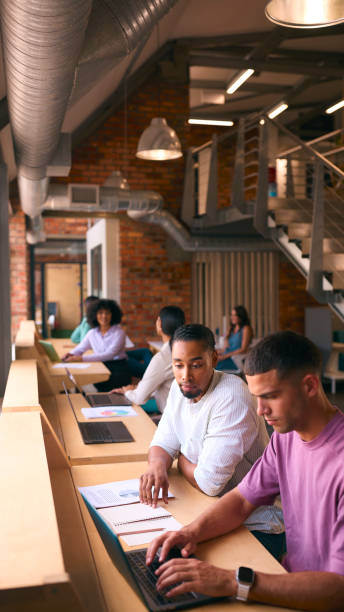 istock Two Businessmen With Laptop Meeting In Office Discussing Documents With Colleagues In Background 2080686404