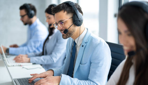 istock Confident handsome call center operator assisting customers, engaged in conversation in the Call Center office. 2080689281