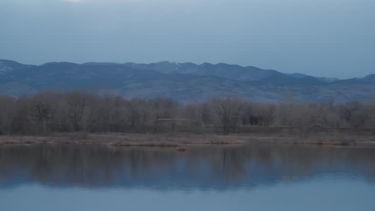 Landscape Panning Across Pond Near Beautiful Mountain Range Blue Lighting