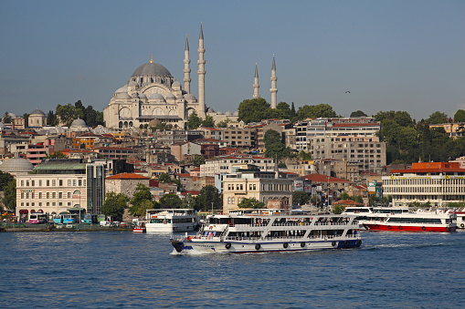 Istanbul, Turkey - March 27, 2011: There are passenger ships on golden horn with its turkish flag and Suleymaniye mosque with Karakoy wiev. It's a medieval stone tower in the Galata/Karakoy quarter of Istanbul, just to the north of the Golden Horn and one of the city's most striking landmarks.