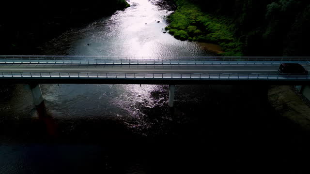 Aerial zoom-out shot of a Bridge over a river viewed from above