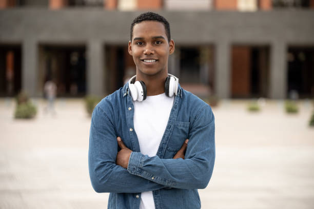istock Young handsome guy smiling and looking at camera relaxed.Satisfied man smiling and standing with arms crossed wearing headphones. 2080703298