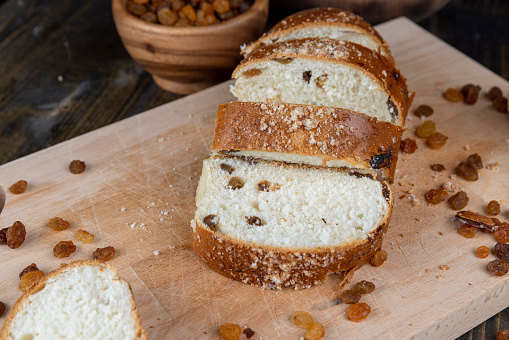 sweet wheat bun with raisins on the table, sweet bun with golden raisins