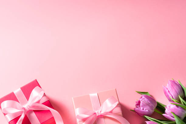 istock Mother's Day border concept background with tulips and gift boxes on pink background. Copy space 2080742396
