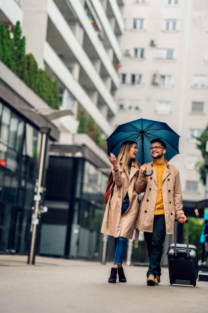 istock beautiful smiling young couple walking in the rain 2080743968