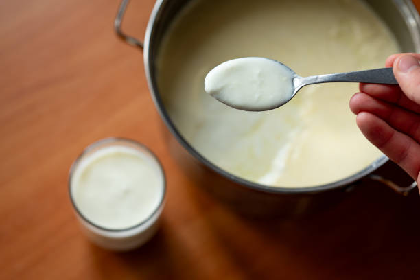 istock Man taking some yogurt from pan to cup for a meal 2080756265