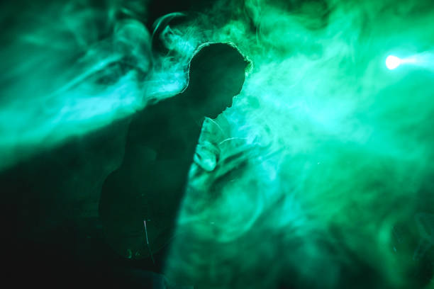 istock Silhouette of a guitarist on stage light and smoke effects. 2080757825