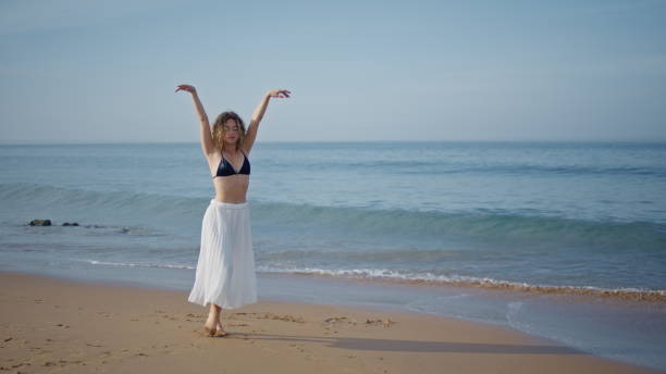 istock Dancer woman raising hands walking summer beach. Performer moving gracefully 2080763074