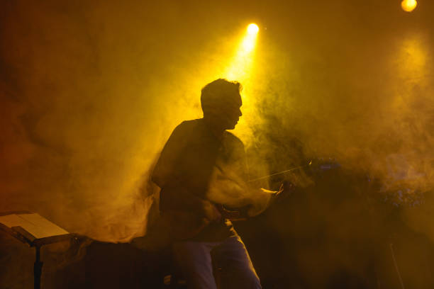istock Silhouette of a guitarist on stage light and smoke effects. 2080765673