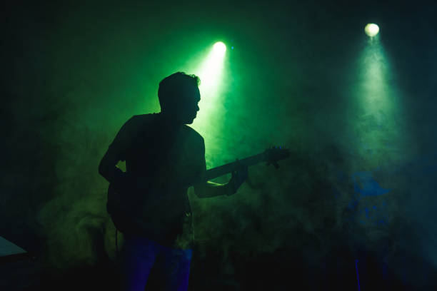istock Silhouette of a guitarist on stage light and smoke effects. 2080767246